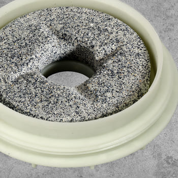 Der obere, stehende Mahlstein mit Gewinde an der Einfassung für die Einstellung der Mehlfeinheit